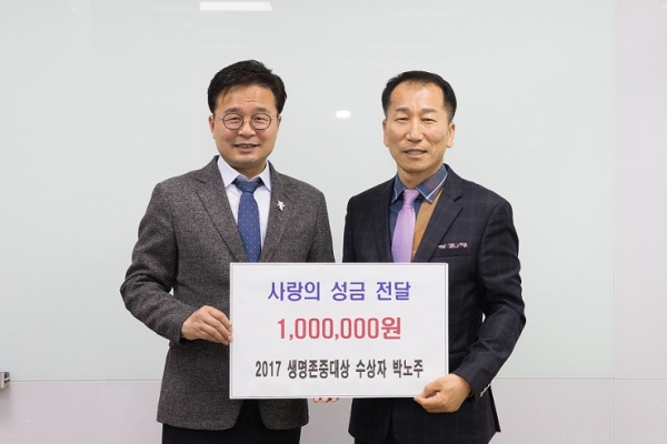 ‘2017 생명존중대상’ 수상자 박노주 전 은평구축구협회장(우측)이 수상 상금을 김우영 은평구청장(좌측)에게 전달하고 있다.