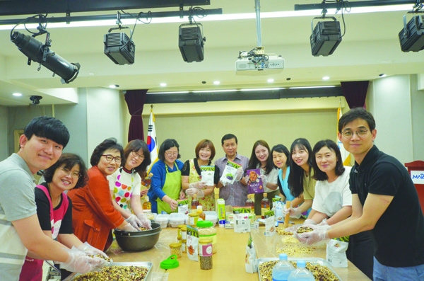 박윤희 아현동장(왼쪽에서 세 번째), 오정금 새마을부녀회장(왼쪽에서 여섯 번째), 신현구 행정민원팀장(오른쪽에서 여섯 번째)을 비롯한 직원과 주민들이 강정을 만들며 기념촬영을 하고 있다.