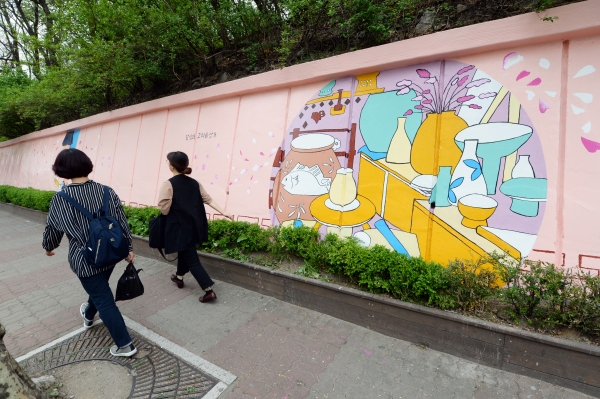 벽화가 그려진 거리를 주민들이 걸어가고 있다.