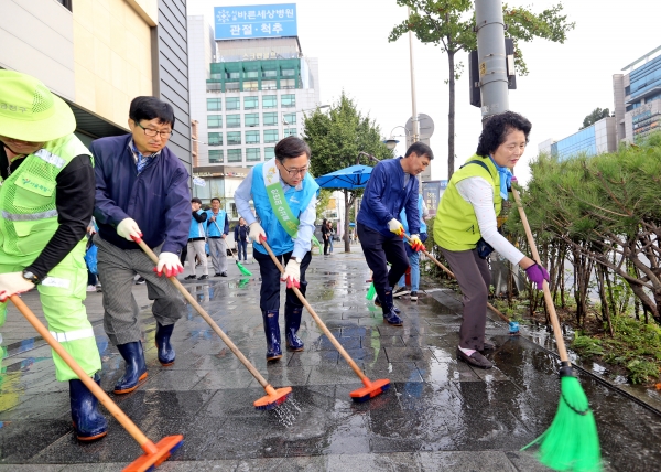 지난 26일 열린 전국체전 대비 서울클린데이 행사에서 유성훈 구청장(사진 가운데)과 주민들이 시흥대로변 보도 물청소를 하고 있다