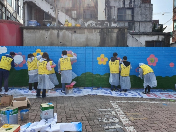 성동구공단 직원들과 자원봉사 참여자들이 성수동 거주자우선주차장에서 벽화를 그리고 있다.