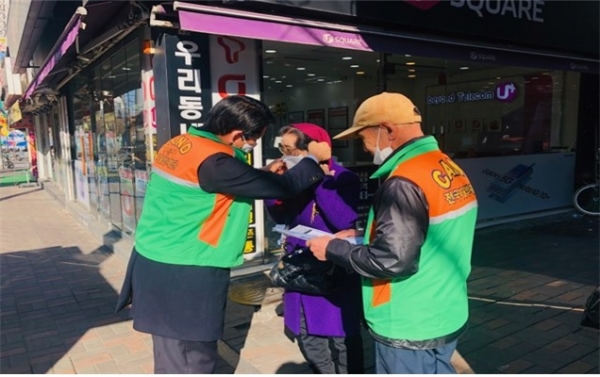 강동구의회 양평호 의원이 주민들에게 직접 마스크를 씌워주며 신종 코로나바이러스 감영증 예방법에 대해 설명하고 있다.