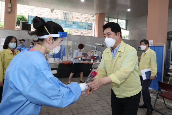 박준희 관악구청장이 관악구 보건소 선별진료소를 찾아 의료진에게 장미꽃을 전달하고 있다