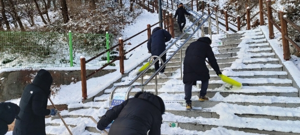 동작공단 직원들이 지난 7일 아침 삼일공원 계단에 쌓인 눈을 치우고 있다.