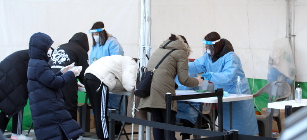 사당문화회관에 마련된 선별진료소에서 주민들이 코로나19 검사를 준비하고 있다.