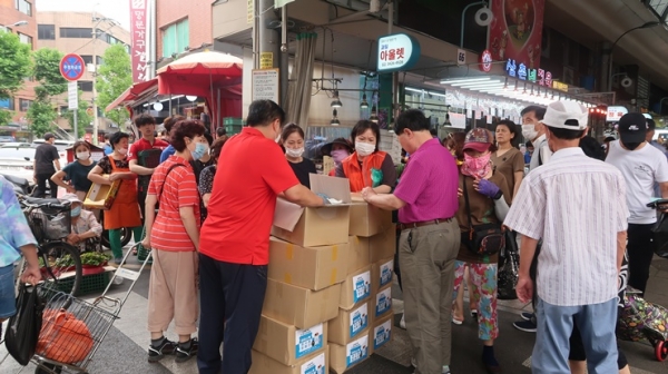 암사종합시장에서 시장 상인들에게 재사용 아이스팩을 나눠주고 있다.