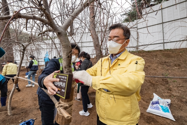 24일 아차산 숲속도서관 건축물 후면 녹지에서 심은 나무에 표찰을 달고 있는 김선갑 광진구청장 모습