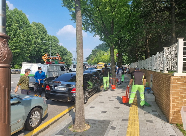 동작구 직원들이 지난달 30일 국립서울현충원 주변 도로를 중심으로 청소하고 있다. / 동작구청 제공