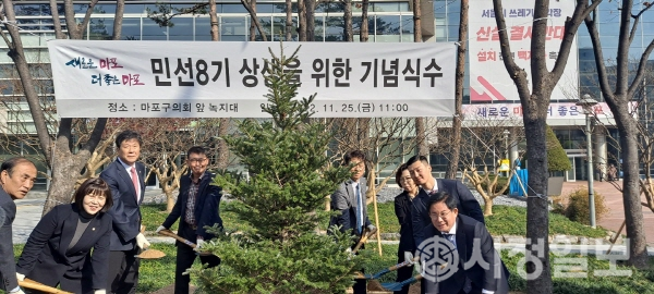 박강수 마포구청장(사진 오른쪽)과 김영미 마포구의회 의장(사진 왼쪽)을 비롯 의원들과 공무원들이 함께 기념식수를 식재하고 있다