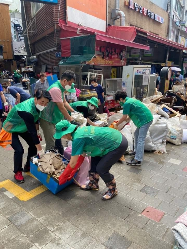 지난 8월 집중호우 시 남성사계시장에서 자원봉사자들이 수해 폐기물 처리를 돕고 있는 모습.