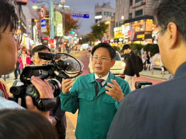 박강수 마포구청장이 TV아사히 기자에게 홍대 레드로드 일대에 설치된 AI(인공지능) 인파관리시스템에 대해 설명하고 있다